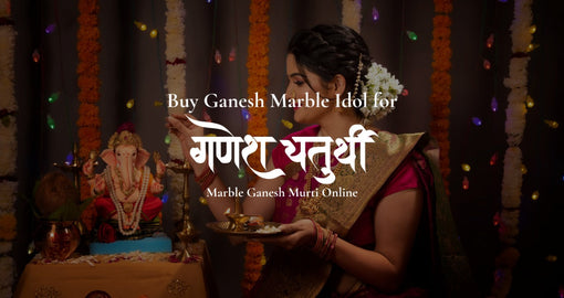 Woman performing Ganesh Chaturthi puja with Ganesh marble idol decorated with flowers and diya